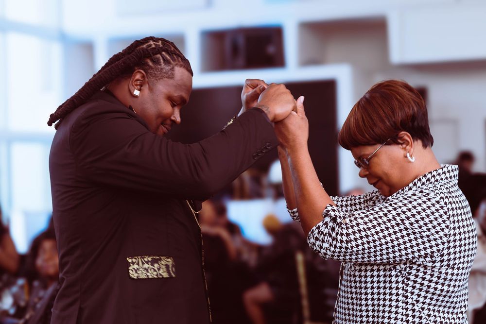 Two people dancing together at a formal event, holding hands in a joyful celebration.