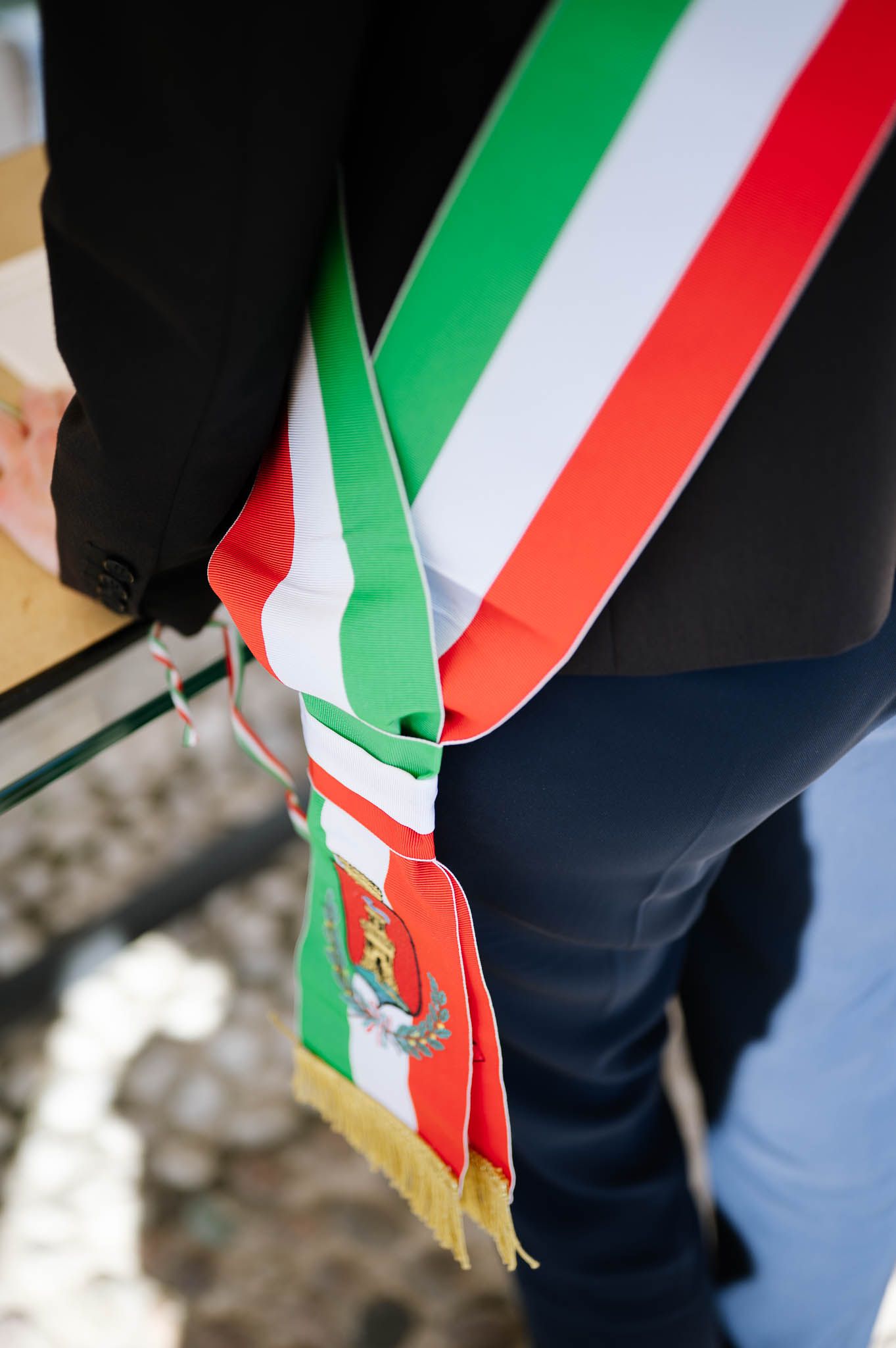 Italian mayor's tricolor sash with gold emblem worn during an official civil wedding ceremony.