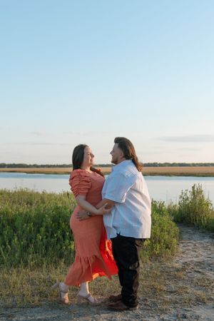 Couple embracing near the ocean in Brunswick, Georgia during a portrait engagement session, southern downtown photography session