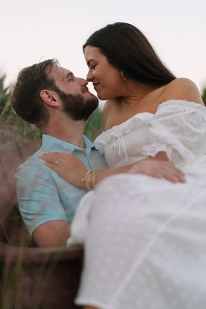 Newly engaged couple snuggles near the beach on Jekyll Island during a portrait engagement photography session