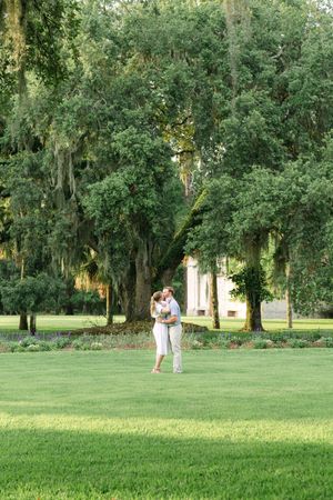 Portrait of couple embracing during a surprise engagement in the historical district near the old buildings of Jekyll Island's best spots