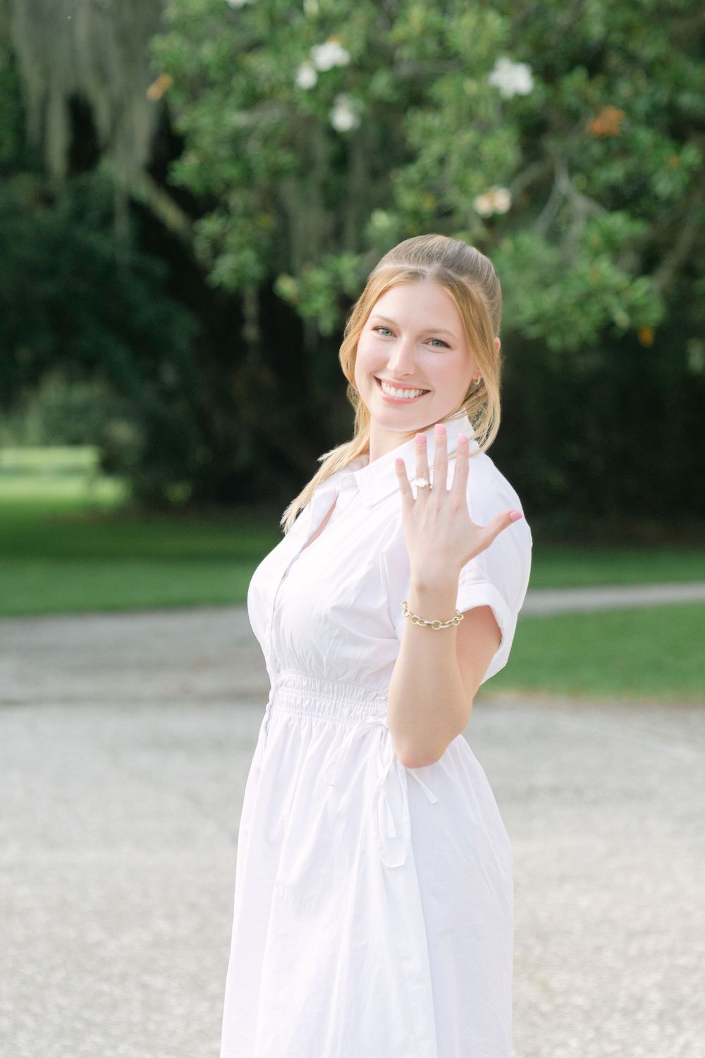 Bride to be wearing white dress showing her beautiful engagement ring during their engagement on Jekyll Island