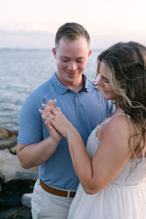 Couple with ocean views behind them, celebrating their engagement session in the Golden Isles