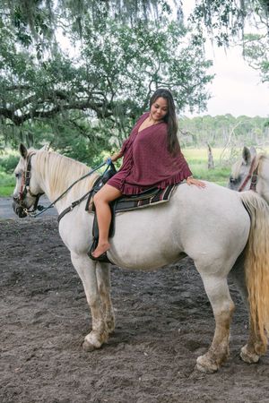 newly engaged fiance sitting on a horse after a surprise beach proposal, going horseback riding on jekyll island photography session
