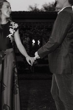 sweet couple embracing with only pinkies black and white shot in the courtyard of sea island resort in southeastern georgia
