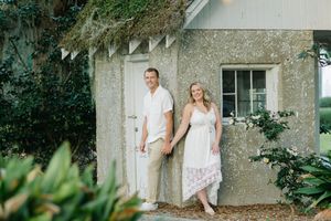 Couple leans casually at Epworth by the Sea's grounds on Saint Simons Island during proposal and engagment session at sunset.