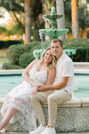 Couple leaning near fountain on St. Simons Island, during engagement photography session with Lindy Rebro, luxury and relaxed