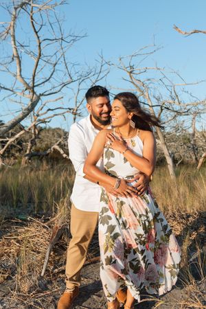 Sweet couple happy to be engaged on jekyll island's corsair beach near the westin inn on Jekyll Island during proposal surprise Lindy Rebro