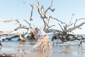 Powerful photo of a couple about to propose on Driftwood Beach on Jekyll Island, during a sunrise early morning proposal with mimosas