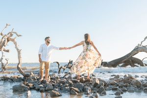 Driftwood beach proposal at sunrise on Jekyll island with beach, rocks and tree views
