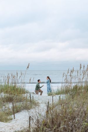 Man on knee proposing during proposal photography luxury session with Lindy Rebro Photography at sunset on Jekyll Island