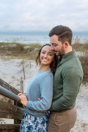 Smiling couple newly engaged on Jekyll Island near the beach paths by the ocean during fall proposal at Sunset.