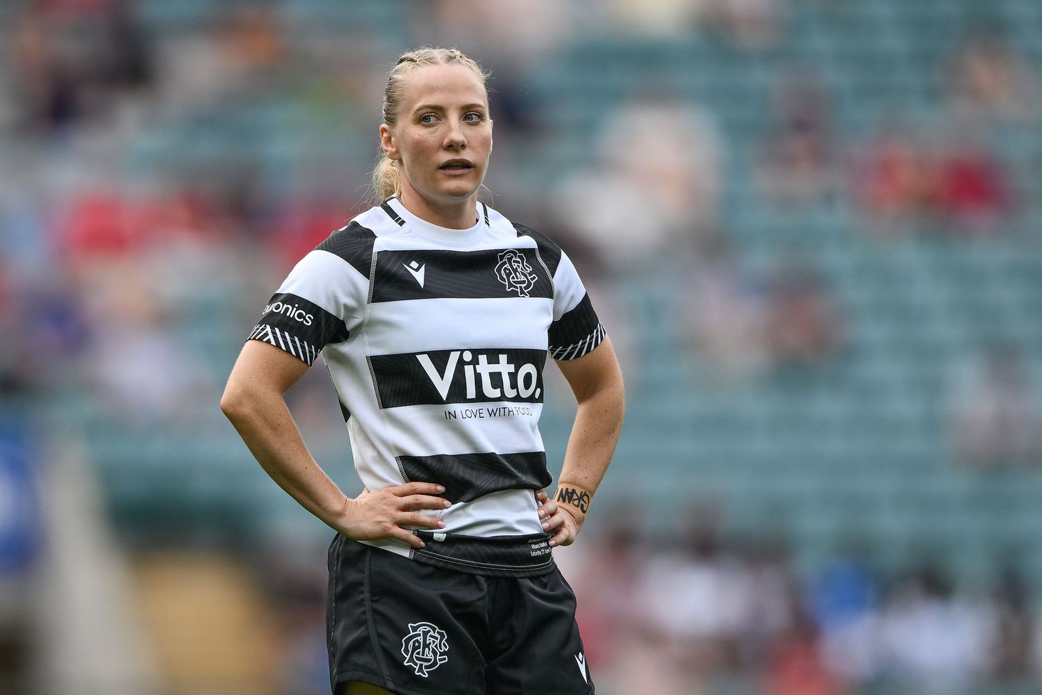 Female soccer player in black and white Vitto jersey stands on field during a match.