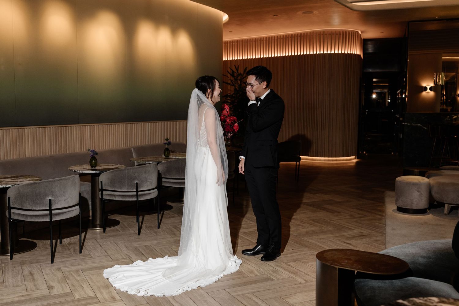 Bride and groom share an intimate first look moment in an elegant hotel lobby before their wedding.