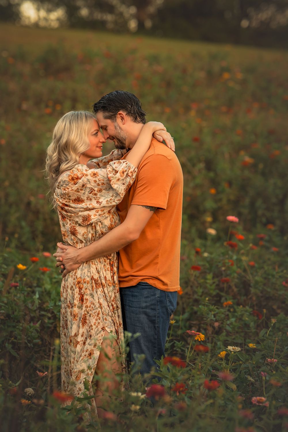 Romantic couple facing each other in a vibrant wildflower field during warm sunset light.