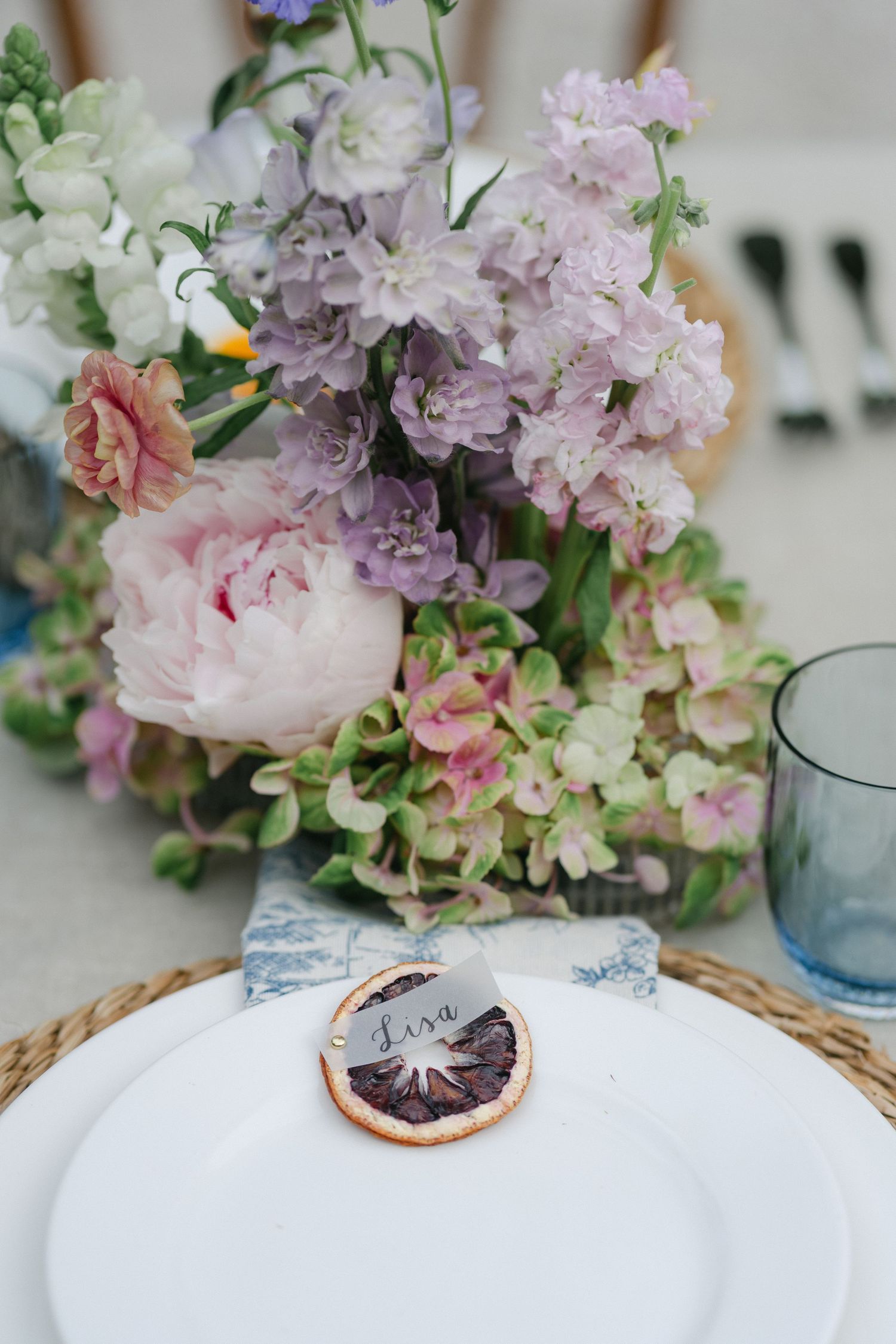 Polaroid photo wedding table plan display on wooden board with travel photos and floral arrangements dated 6.20.26.