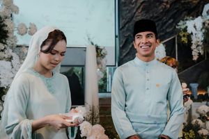 Malaysian couple in traditional Baju Kurung and Baju Melayu attire at an elegant wedding ceremony.