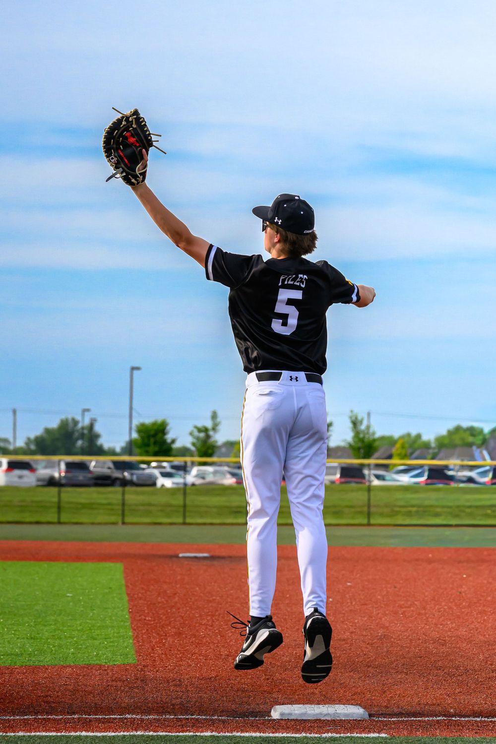 L Squared Photography sports portrait first baseman jumping to catch the ball