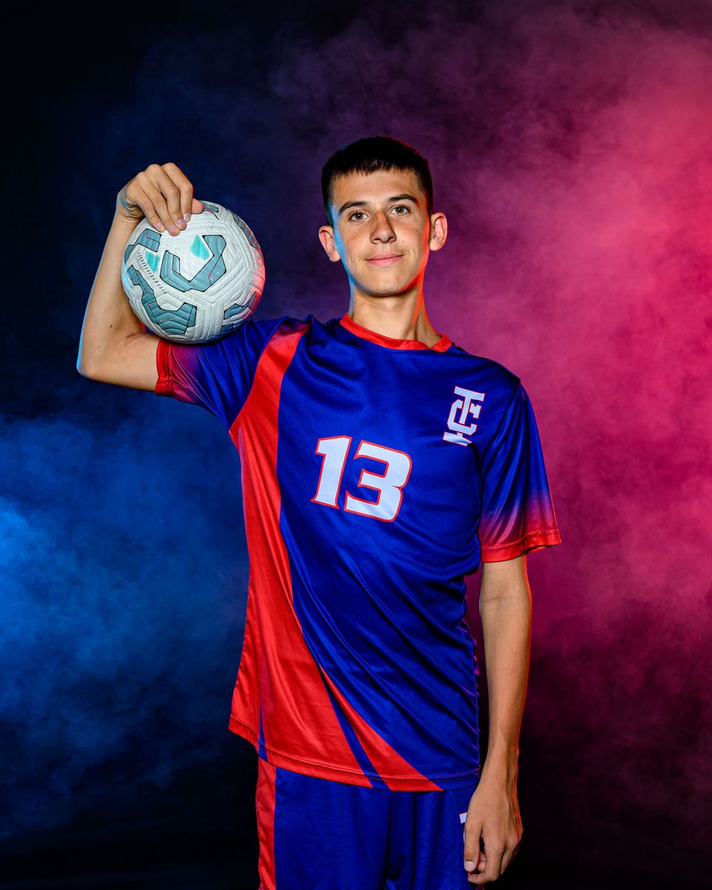 L Squared Photography sports portrait soccer player with red and blue smoke