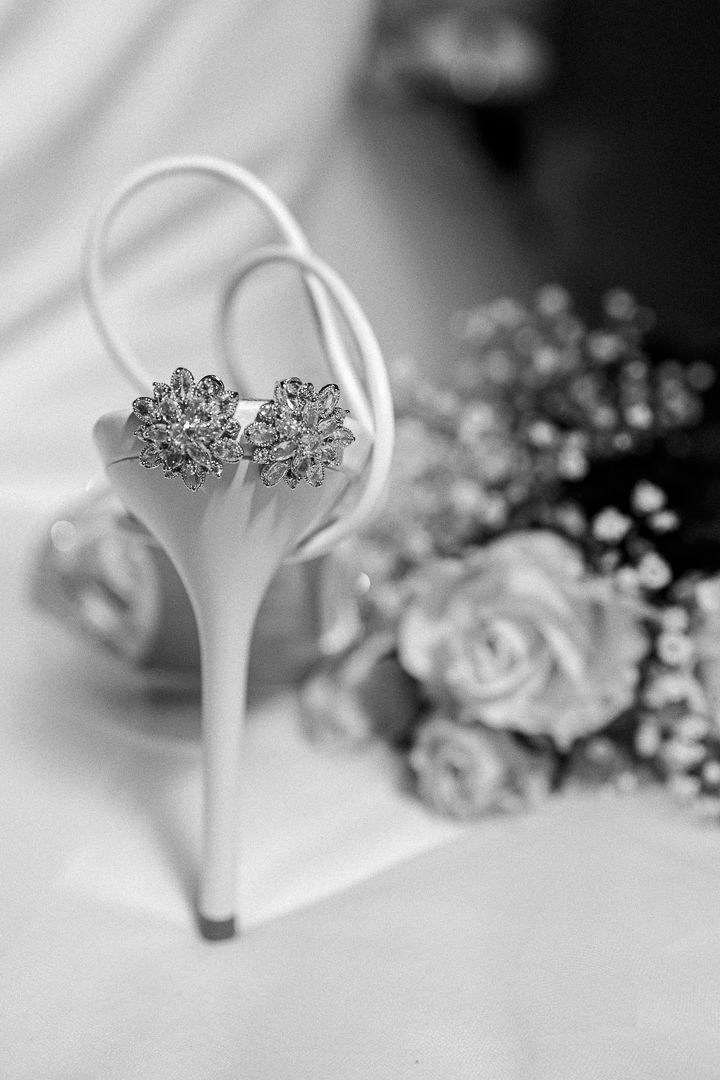 Black and white photo of a man in a tuxedo fastening his cufflinks, preparing for a formal event.