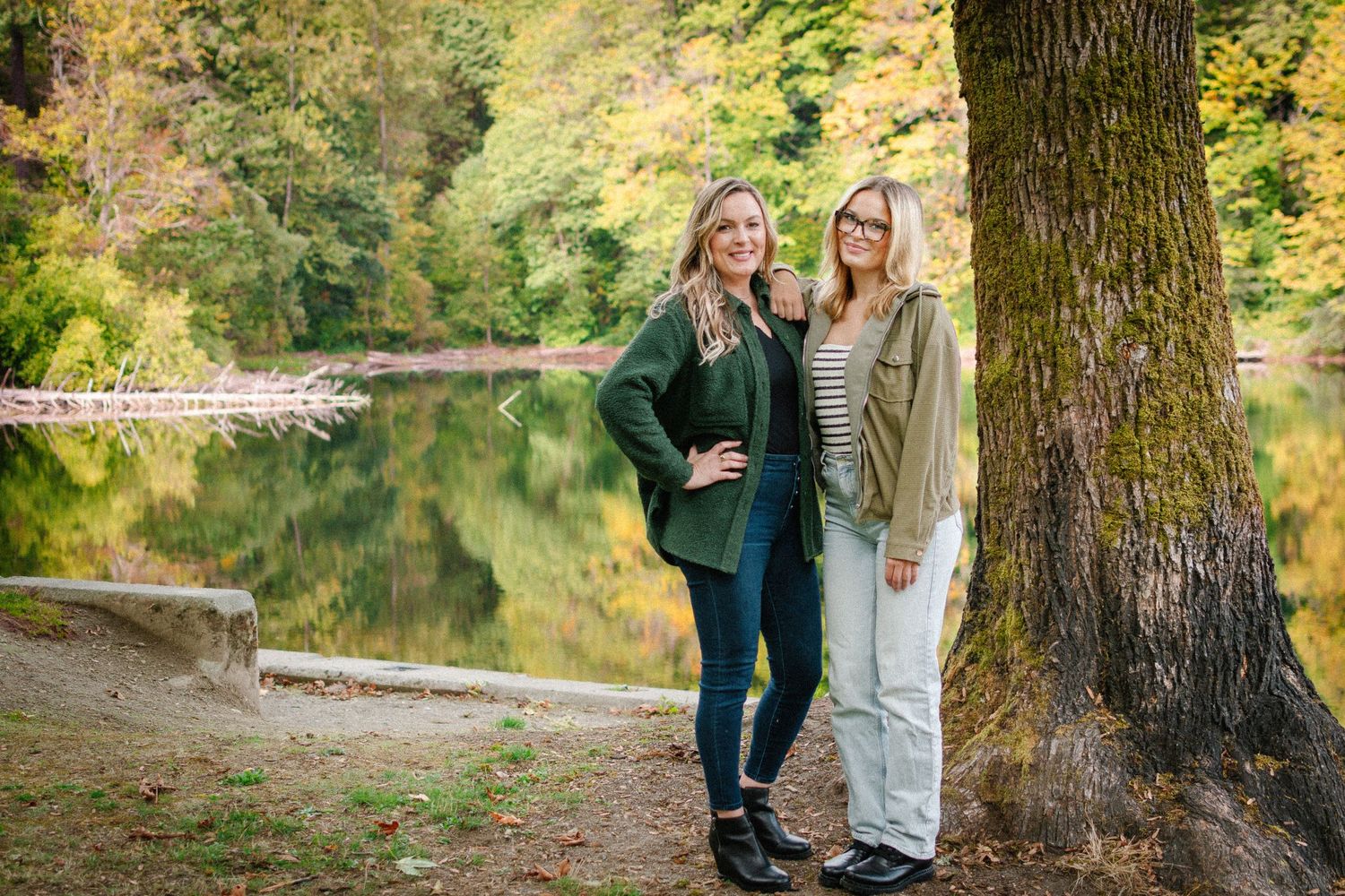 Mother and daughter wearing coordinated green outfits for autumn portraits beside Lake Fenwick in Kent, Washington.