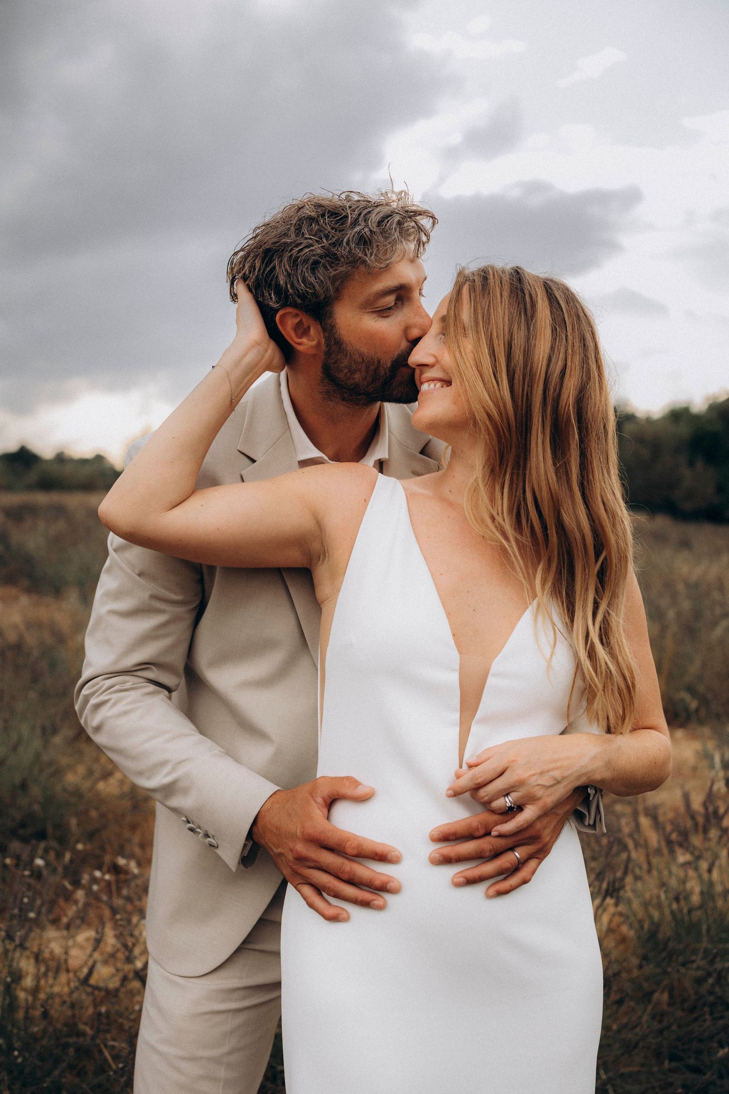A tender autumn embrace captured during a wedding photoshoot with fall foliage.