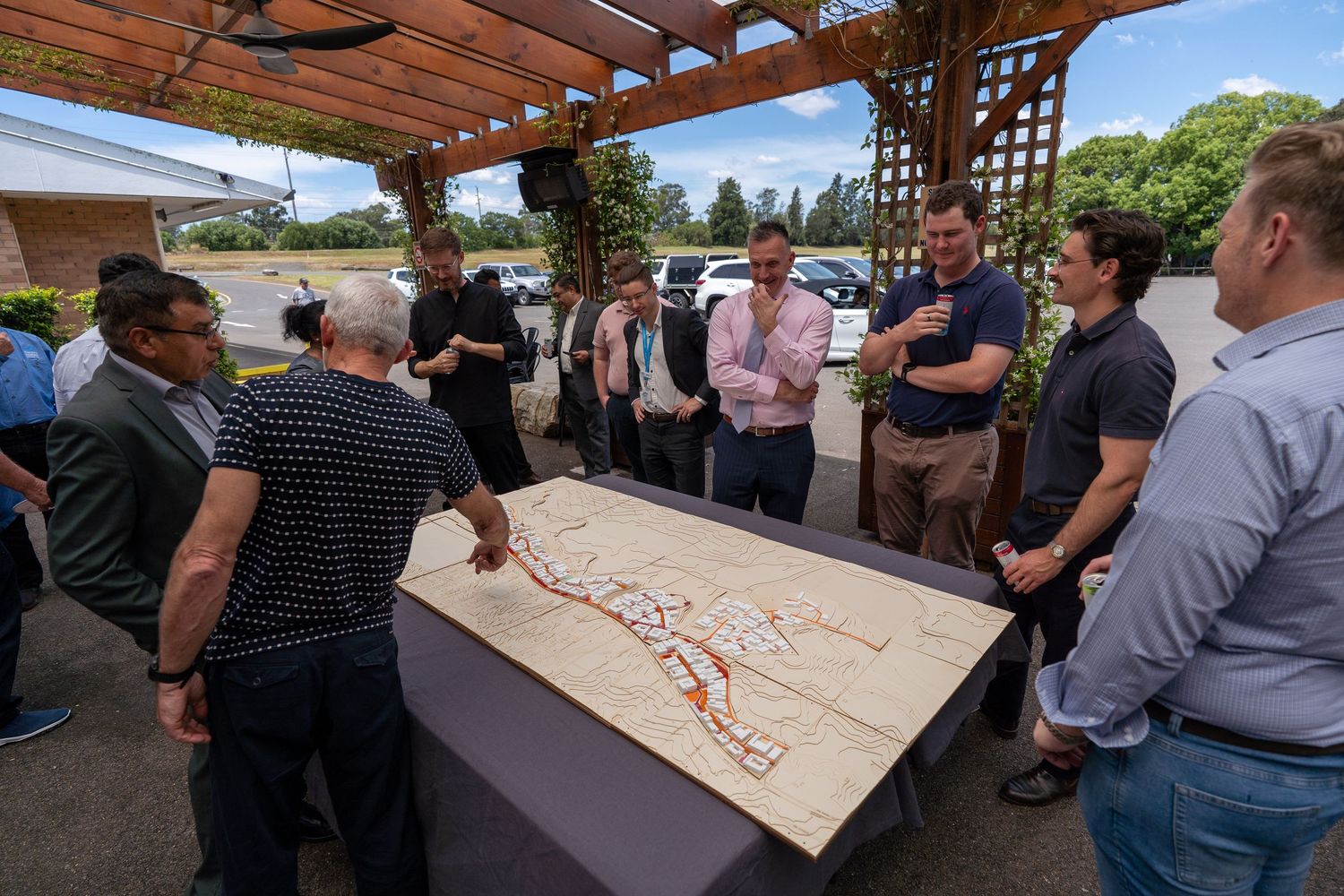 Business professionals reviewing large city planning map displayed on outdoor table.