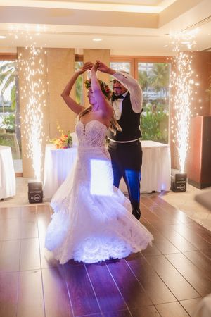 Bride and groom share their first dance surrounded by sparkling fireworks at an elegant wedding reception venue.