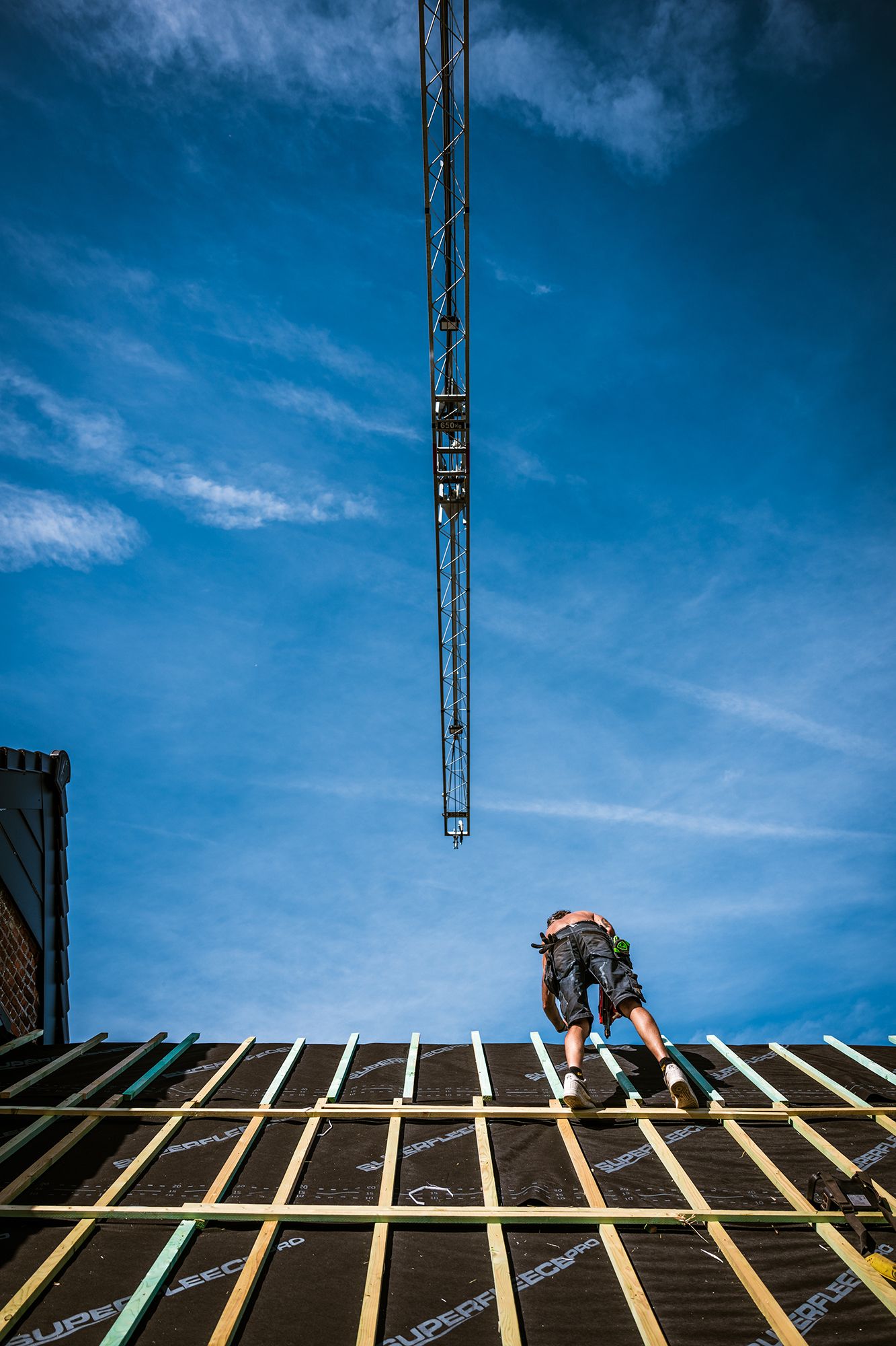 Werffotografie van een dakwerker aan het werk op een bouwproject, gefotografeerd door Bart Boodts Photography