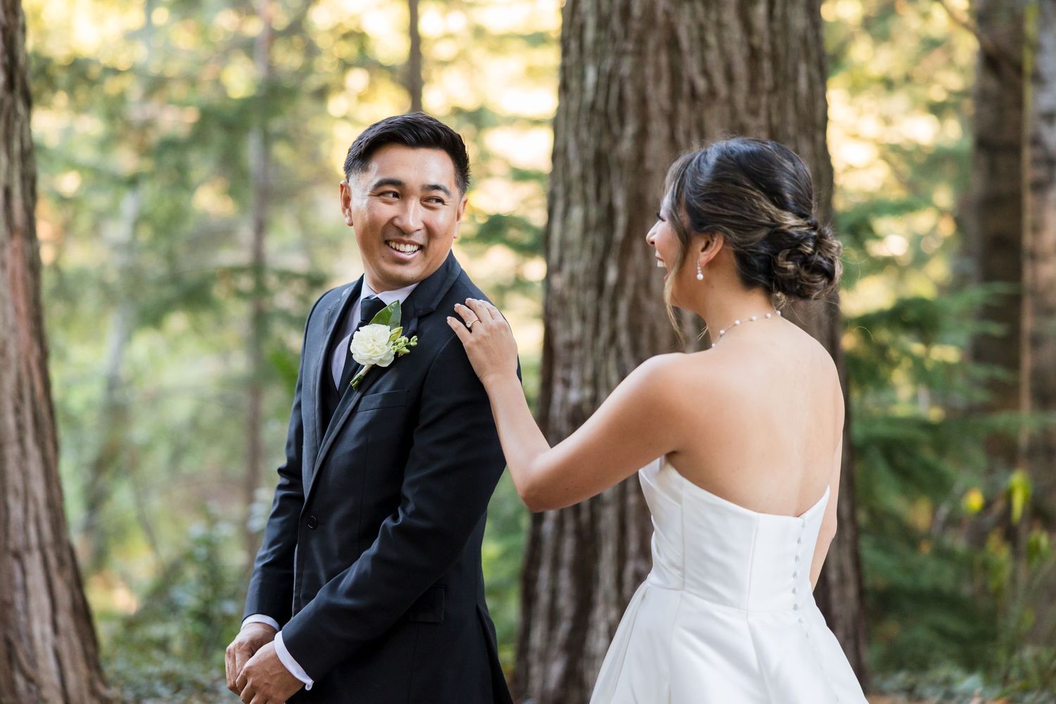 Couple sharing a romantic dip kiss on a sunlit mountain meadow at golden hour in wedding attire.
