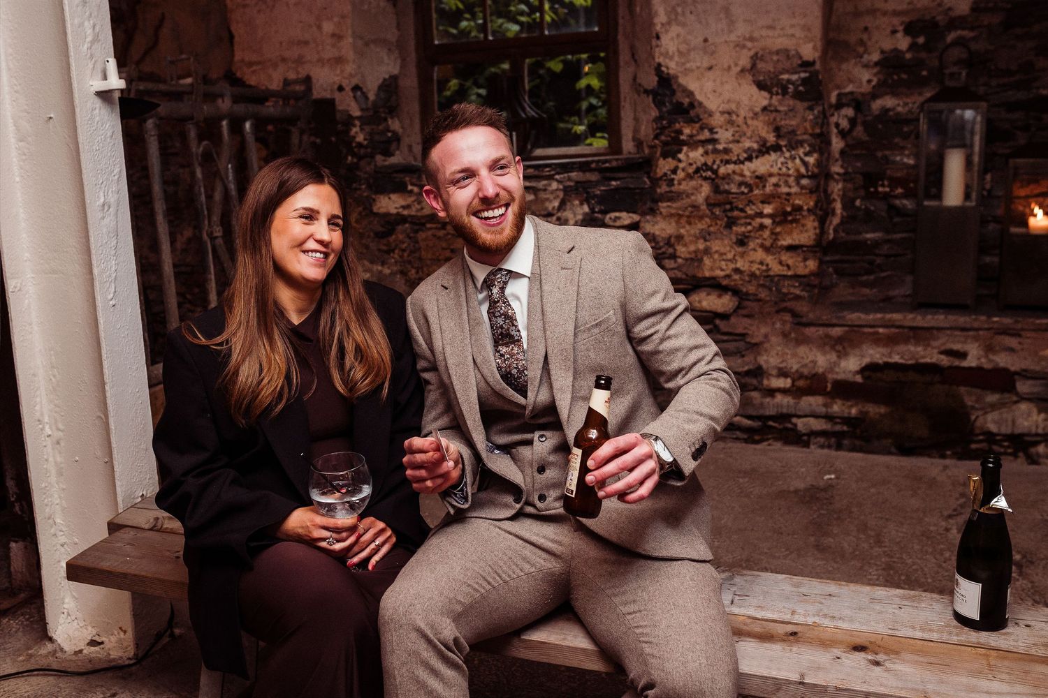Elderly couple smiling and holding champagne glasses at a formal wedding reception event.