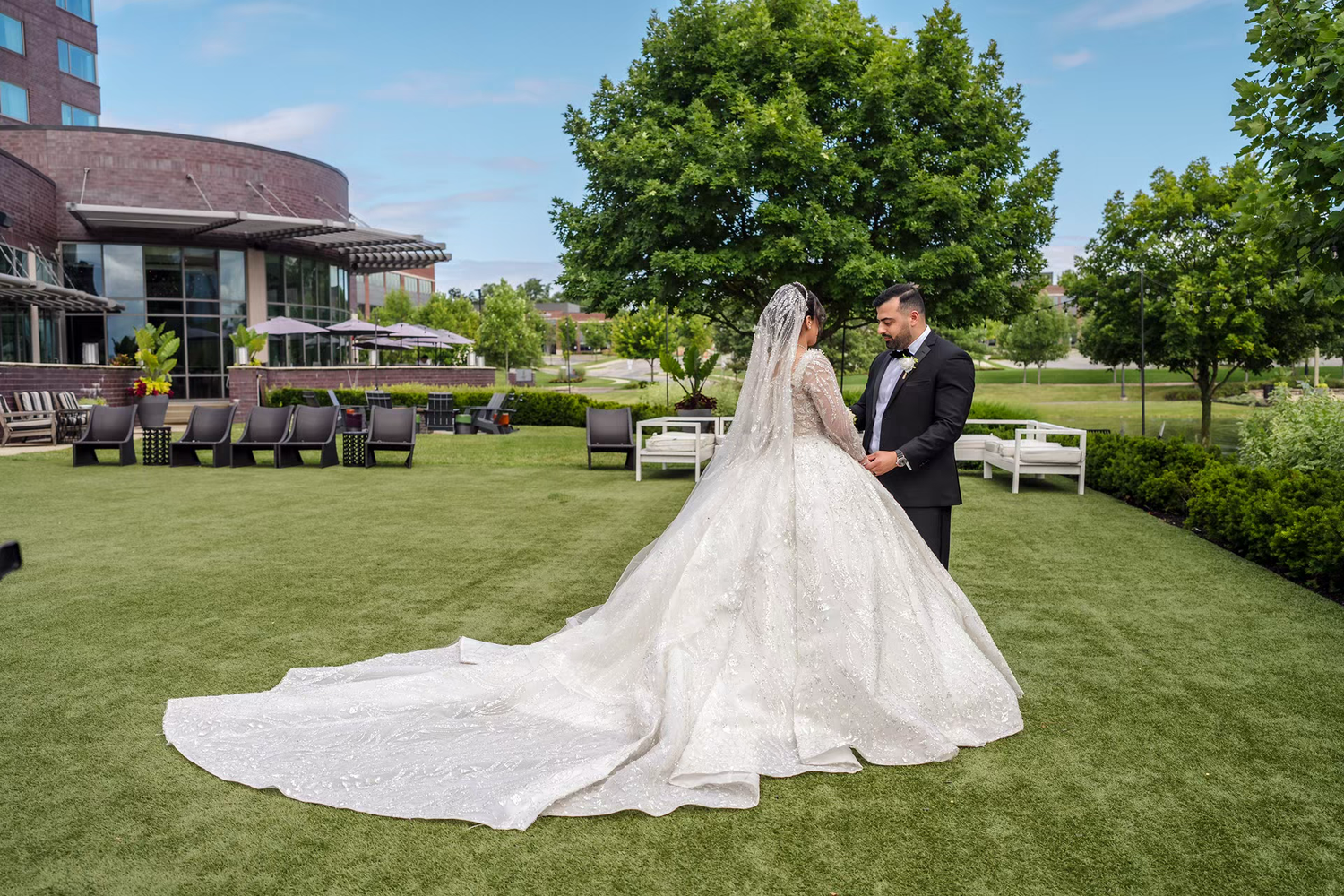 Bride and groom stand outdoor first look at renaissance outdoor wedding venue.