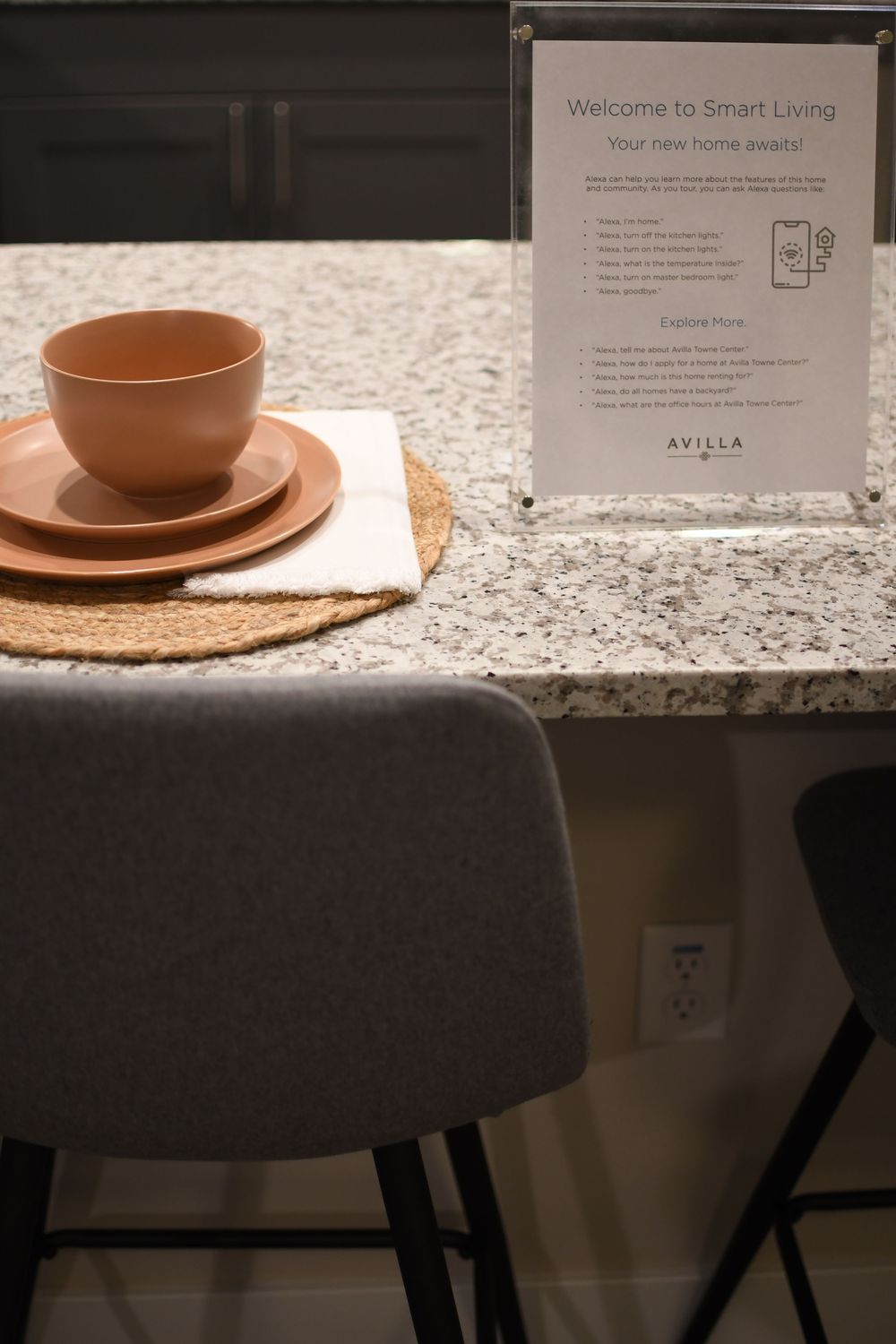 Avilla Smart Living welcome sign on granite countertop with terracotta bowl and plates on woven placemat.