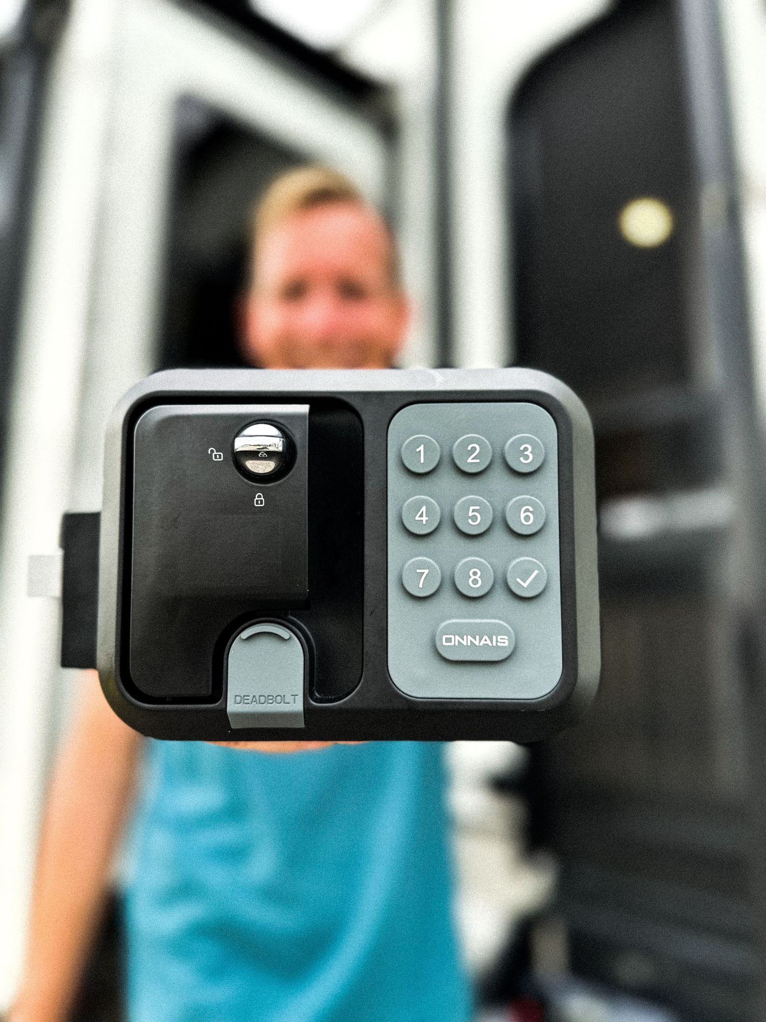 Person holding an Onnais keypad smart lock for an RV door, showcasing keyless entry technology.