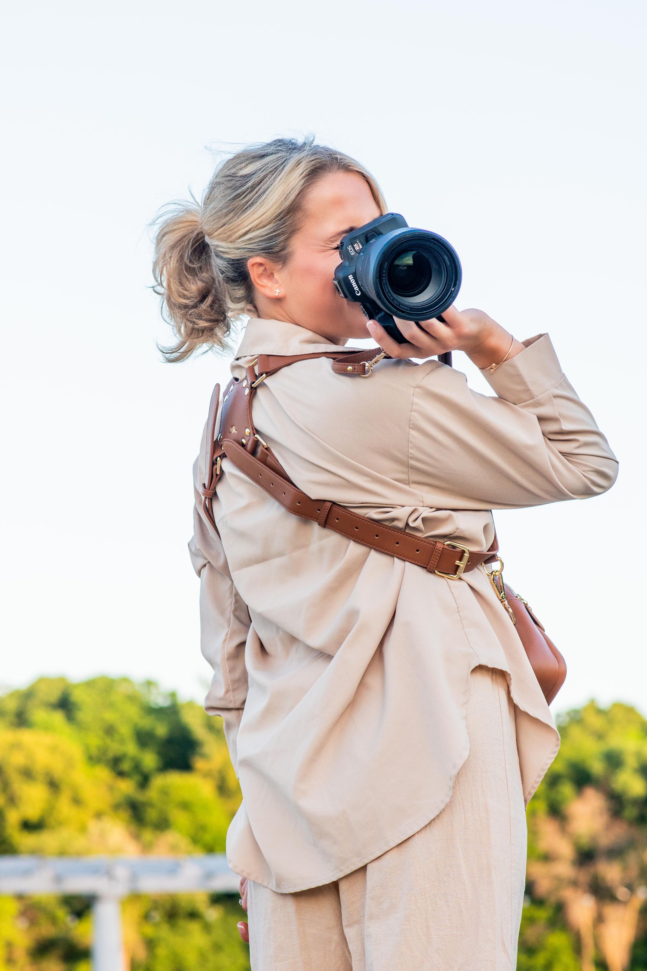 Candid outdoor portrait of photographer Danielle Taylor with her camera, showcasing her natural, documentary lifestyle media brand.