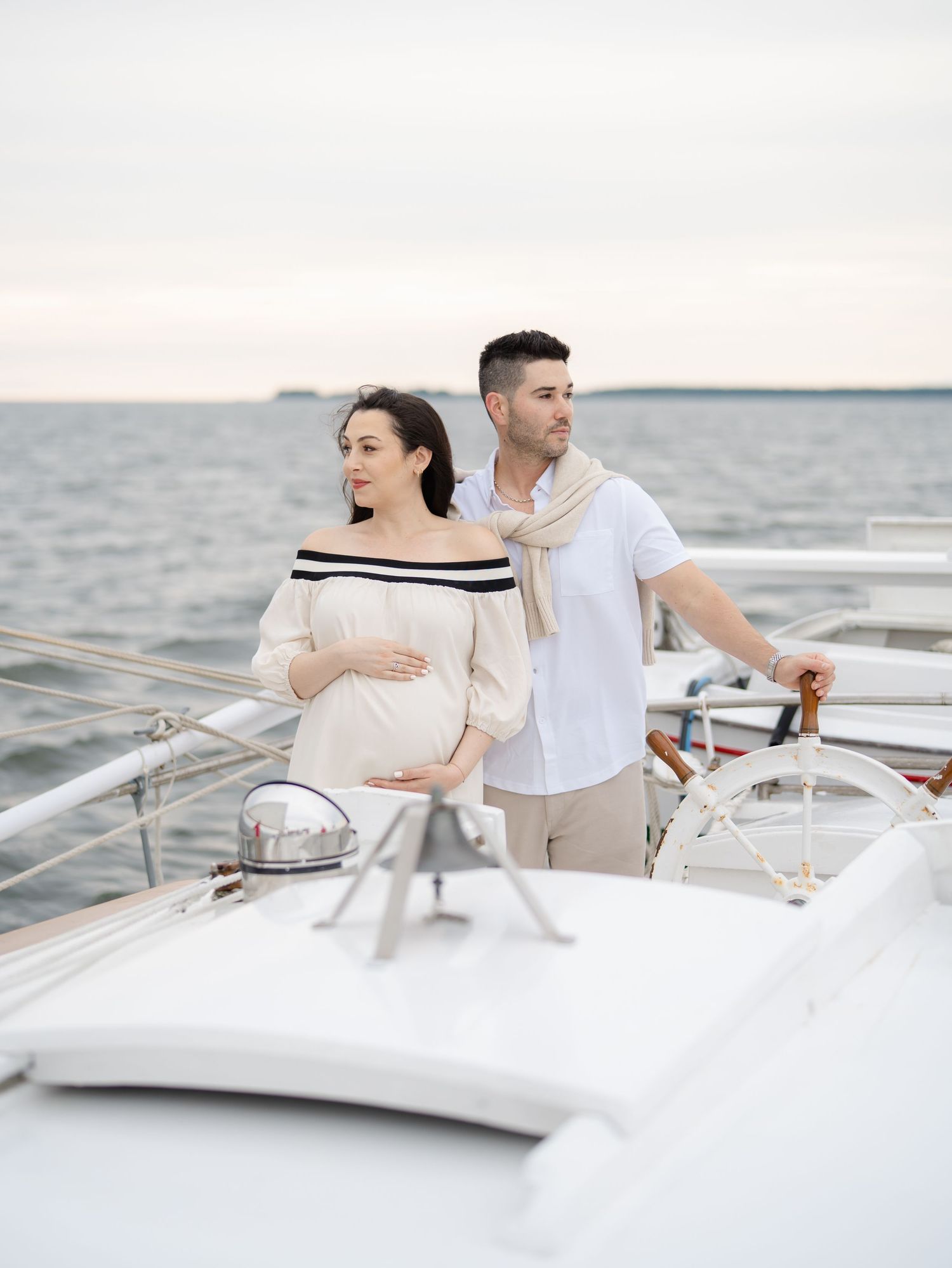 A maternity session with a young couple driving sailboat while belmar nj photographer photographs the journey.