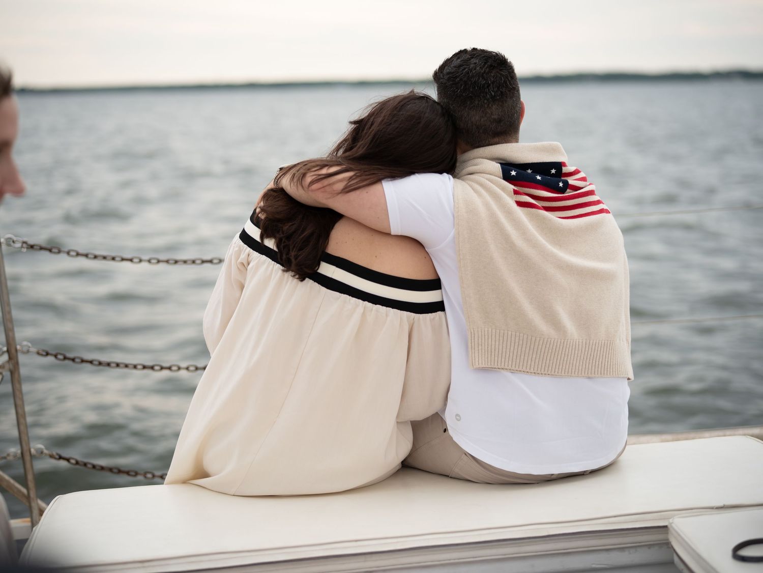 A young couple looks out over the water while lauren marie photography captures the sweet moment with a film camera.