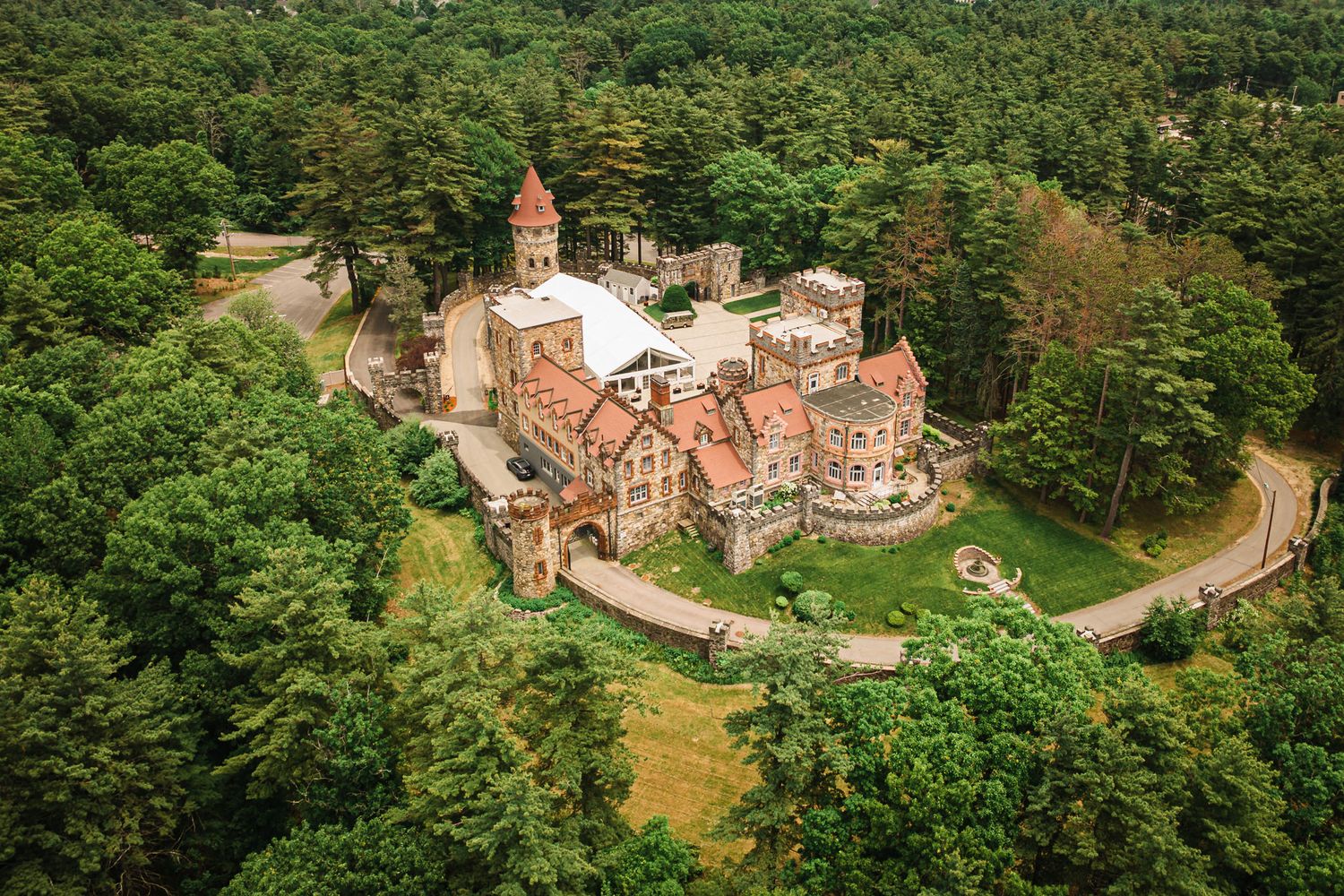 Aerial view of Searles Castle in Windham, NH, showing the entire castle estate, reception tent, and surrounding forest.