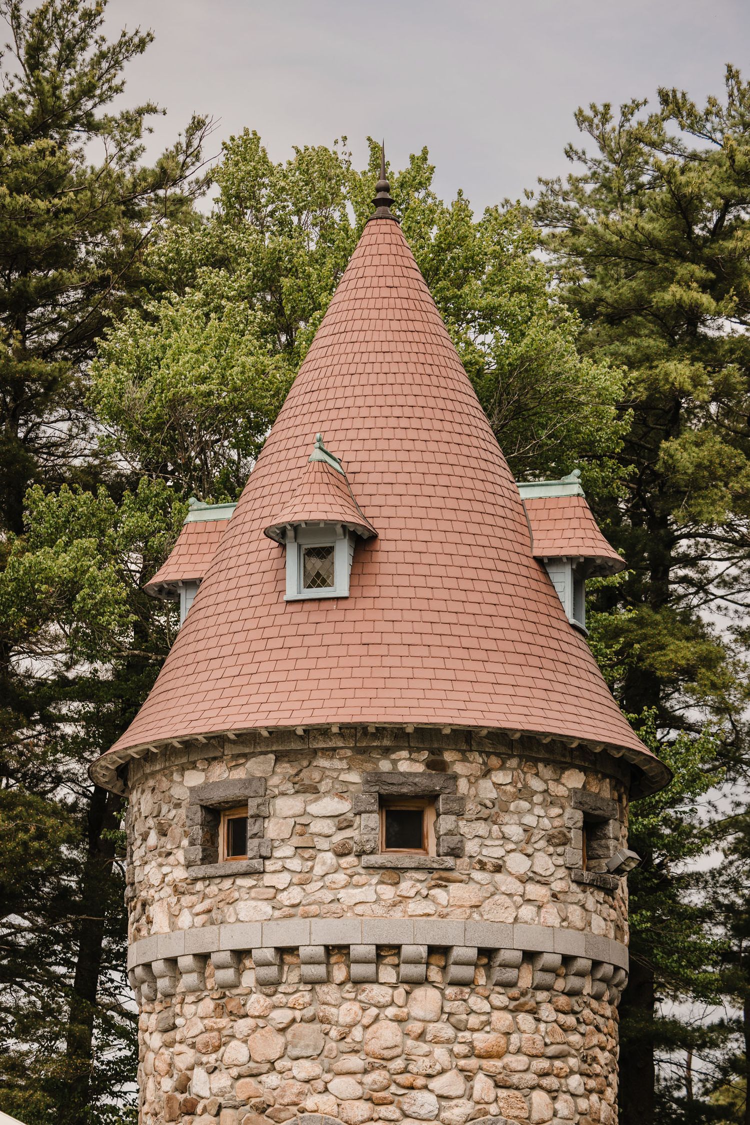 Close-up of a stone turret with a conical red tile roof at Searles Castle, the wedding venue in Windham, New Hampshire.