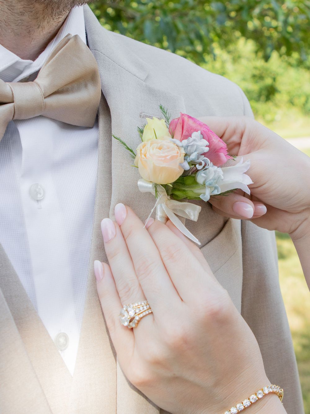 bride pinning the boutonnière on groom for their wedding day in strongsville.