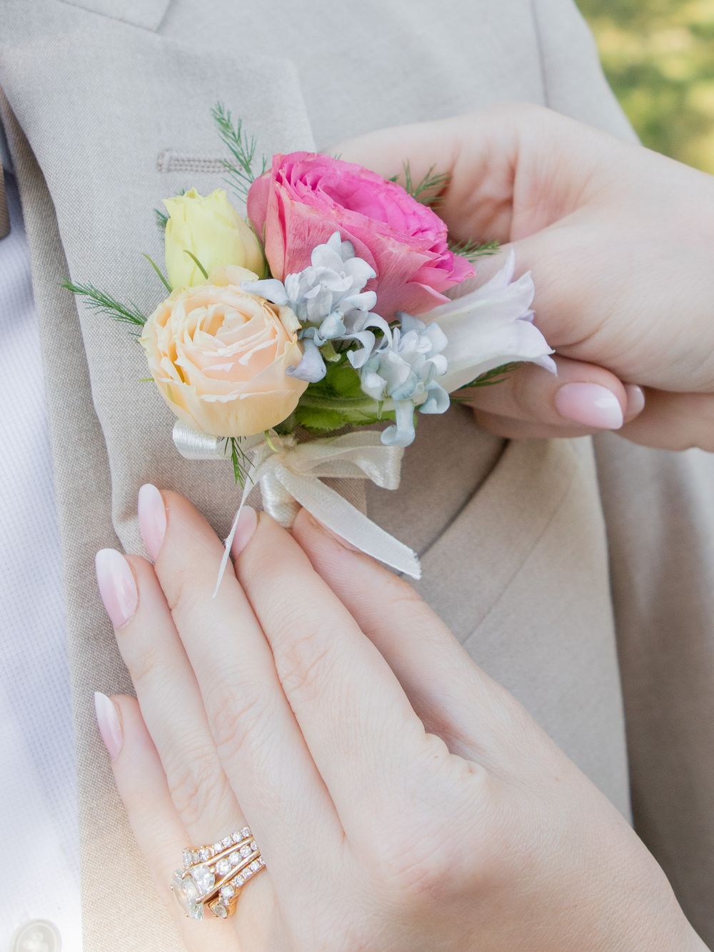 Bride pins boutonniere on groom in Strongsville for their wedding.
