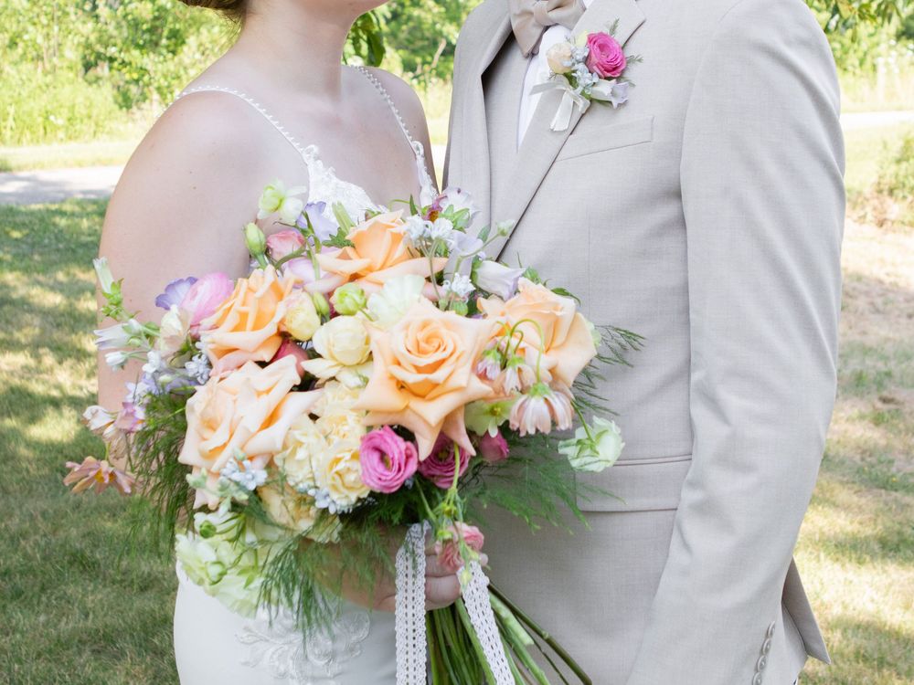 husband and wife with a bouquet of vibrant flowers in strongsville