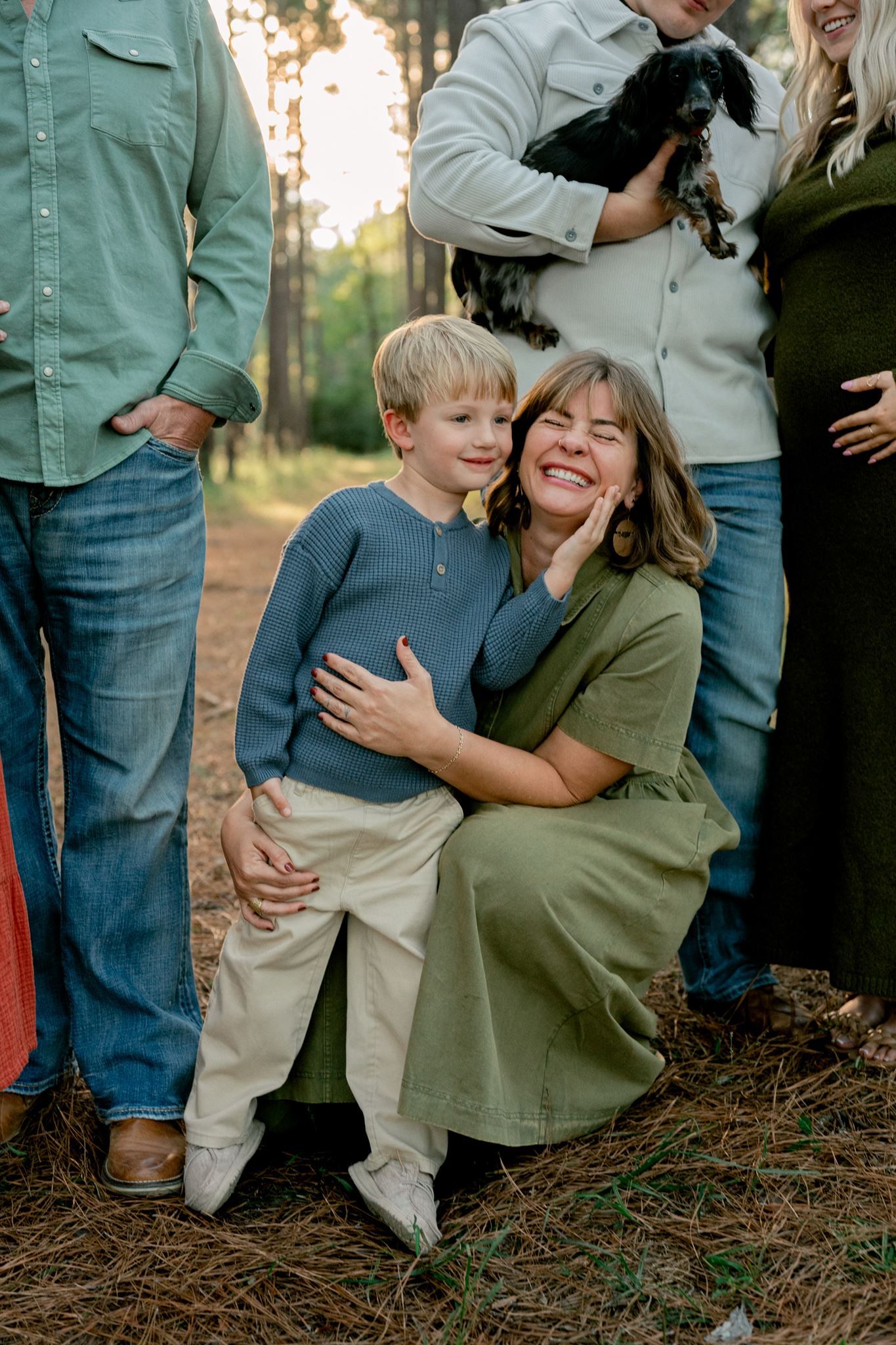 Mother squatting down to her toddler son laughing together.