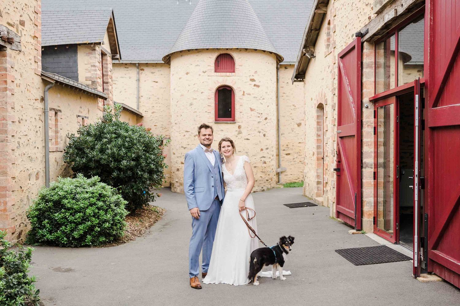 Un couple de jeunes mariés avec leur chien lors de leur mariage