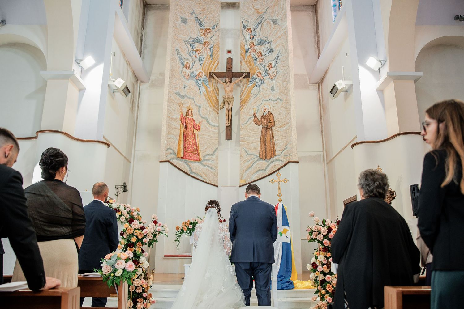 Veduta della chiesa con gli sposi davanti all’altare e gli invitati tra i banchi.