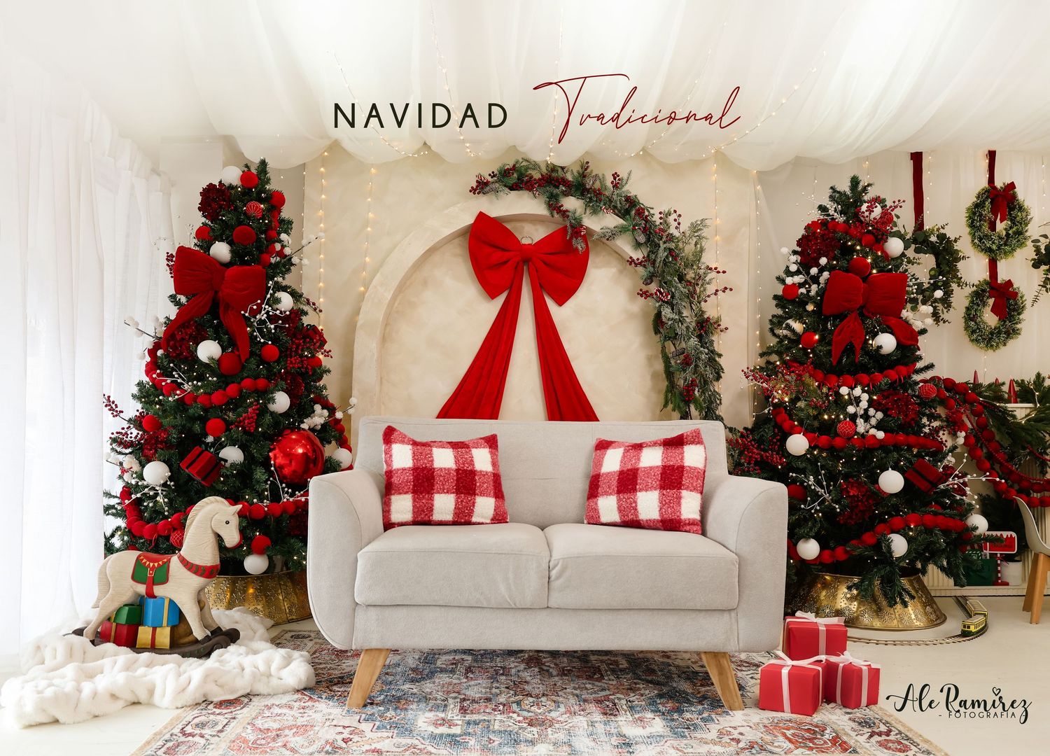 Traditional Christmas living room with red-decorated trees, a white sofa, red bow arch, and festive holiday decor.