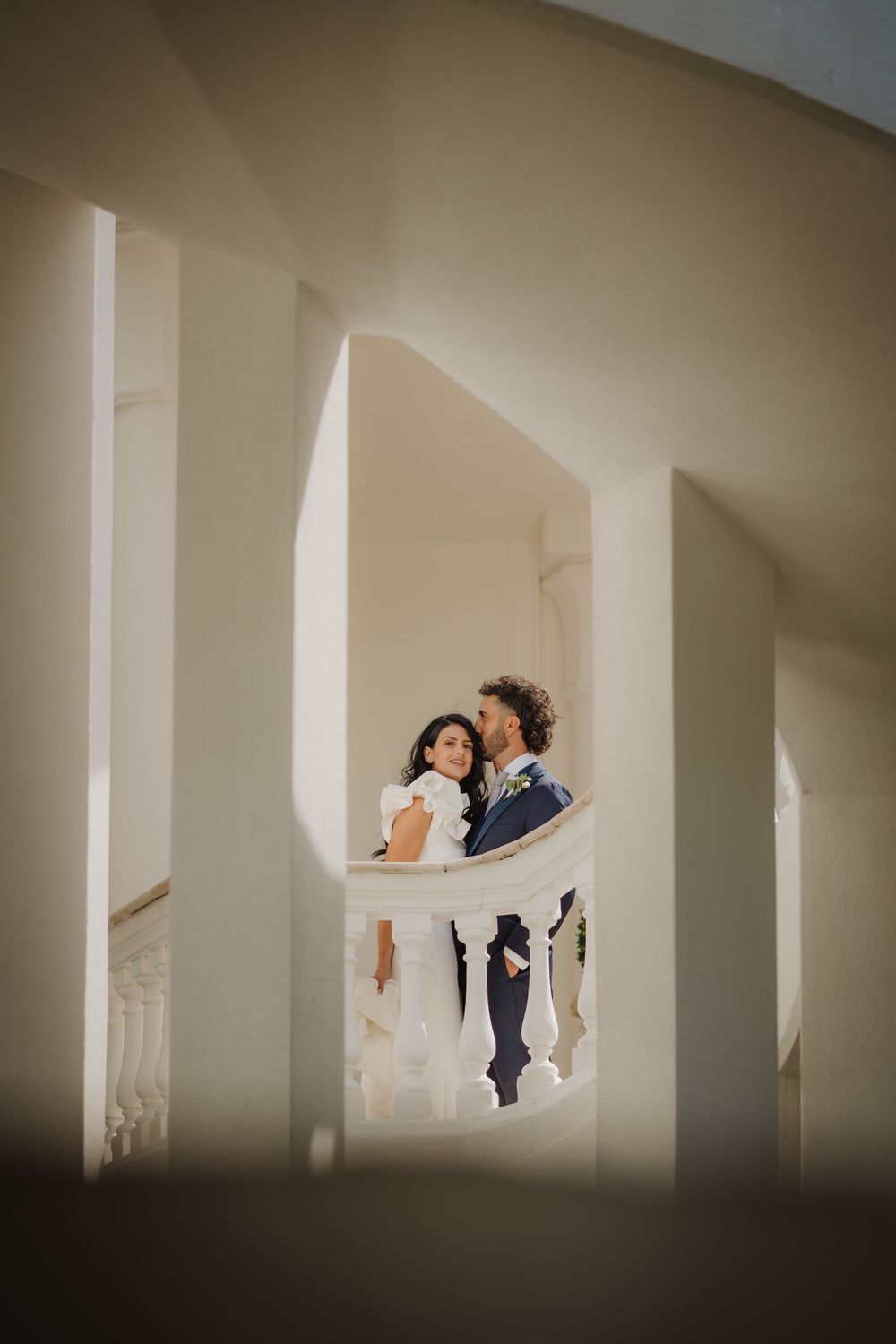 Lorenzo e Laura tra le pareti chiare e la balaustra durante i ritratti di coppia.