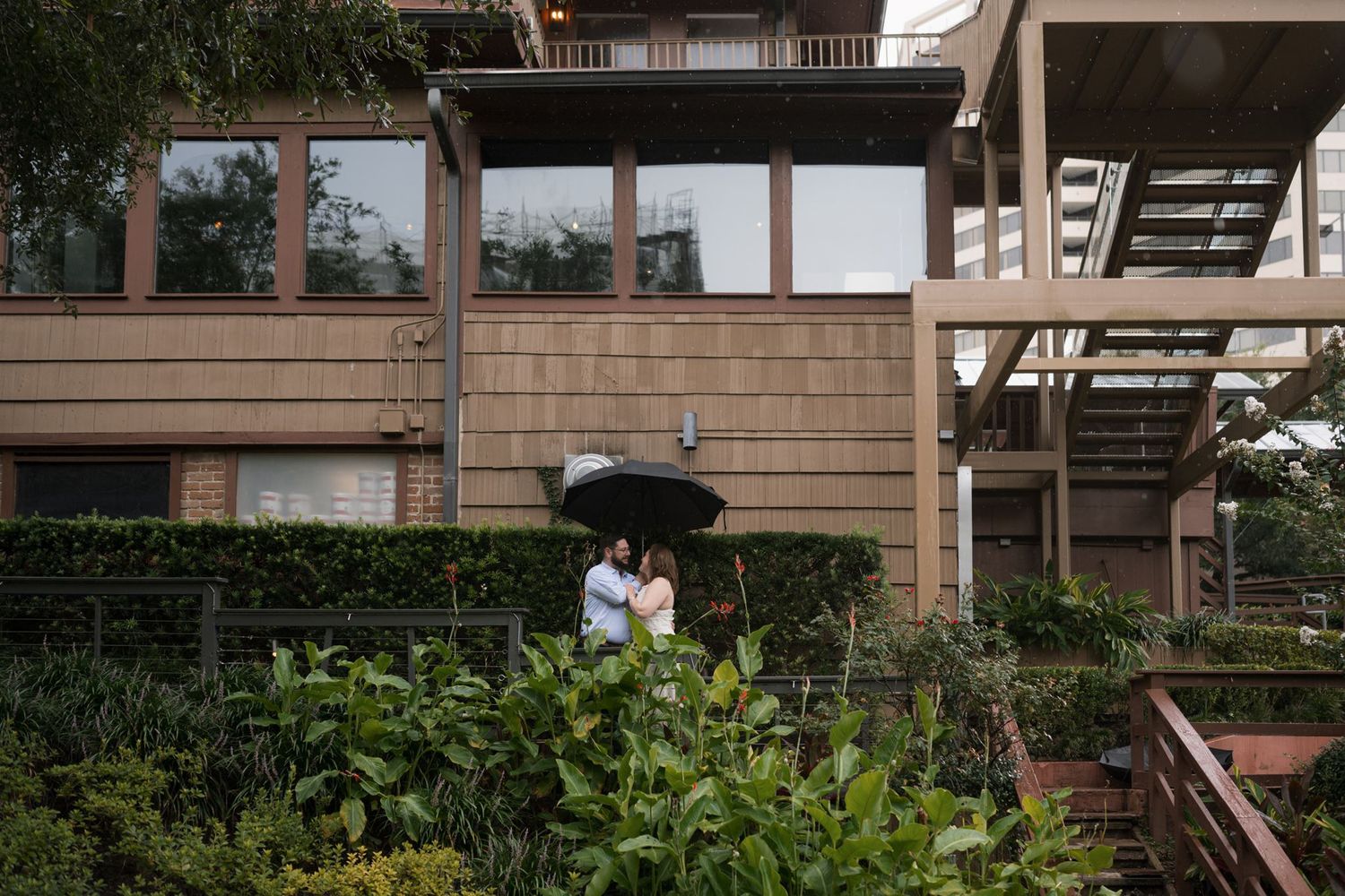 Rainy-day engagement portraits in the gardens at Brenner's on the Bayou