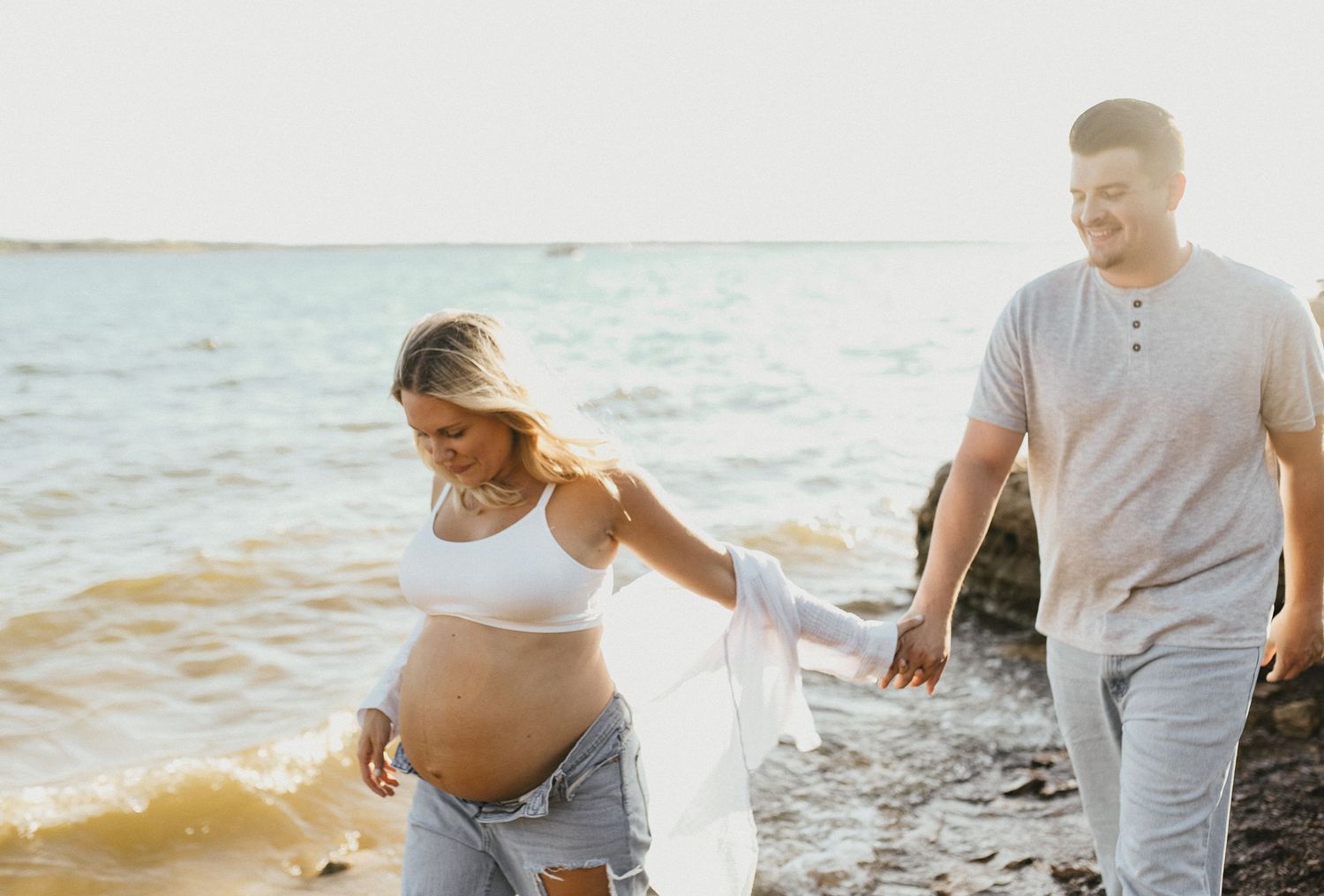 Expecting mother wearing denim shorts and a flowing linen shirt for Lake Grapevine maternity photos