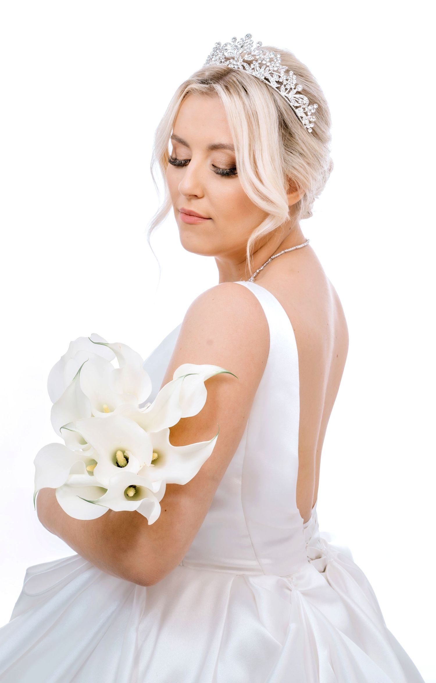 Elegant bridal portrait with white calla lily bouquet and crystal tiara.